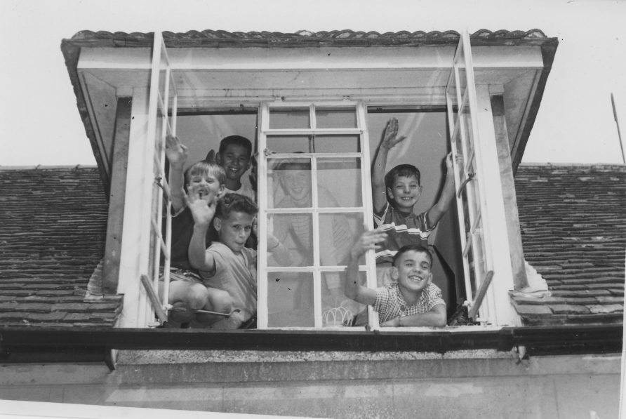 Stables-window A group of boys wave from one of the windows in their accommodation in the Stables complex. Left from top: Arnold, Richard and Juek. Behind the centre glass: Stachek. Right from top: Leonard and Niko. | From the earlypestalozzichildren.org.uk website