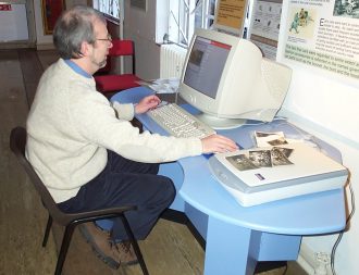 Volunteer Gerry Allen entering loaned items onto the data base