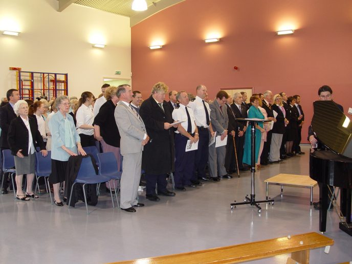 Guests1 The assembled guests stand in preparation for the official unveiling of the Miners memorial.