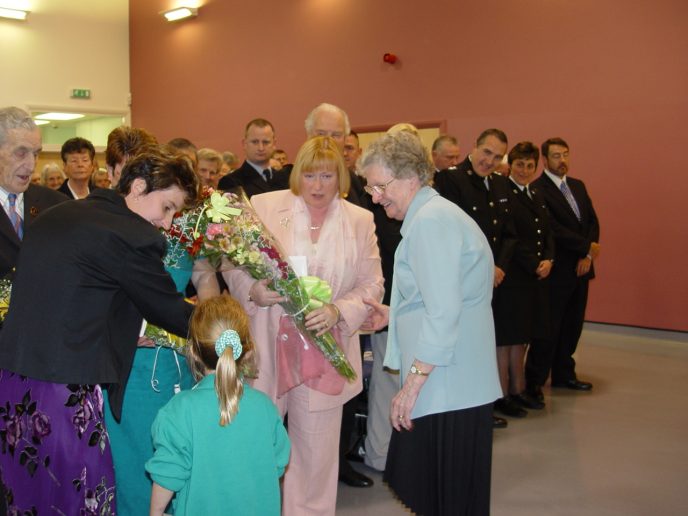 Presentation_of_flowers_to_AMs1 Amy-Leigh Daniel of Ogmore Vale Primary School, presents a bouquet to Edwina Hart AM, MBE. Joanna Daniel and Peggy Hughes look on.