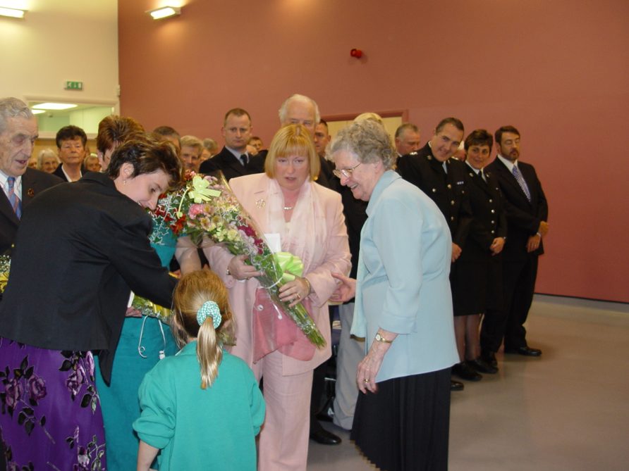 Presentation_of_flowers_to_AMs1 Amy-Leigh Daniel of Ogmore Vale Primary School, presents a bouquet to Edwina Hart AM, MBE. Joanna Daniel and Peggy Hughes look on.