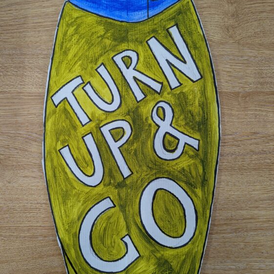 A hand painted cardboard cutout resembling a shampoo bottle. Over the bottle it says 